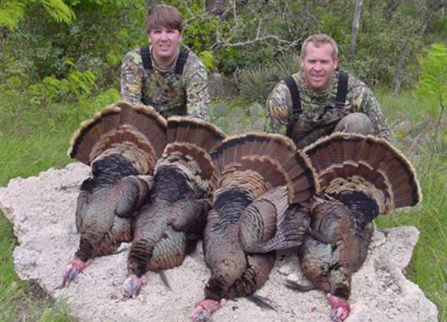 Two hunters with tagged turkeys
