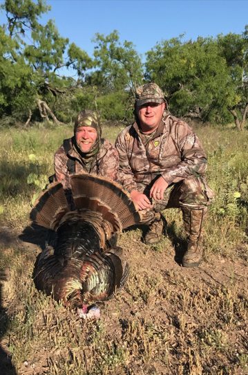 Two hunters with a tagged turkey